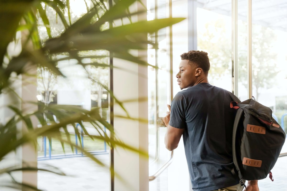 African Student Leaving School Buidling with Backpack